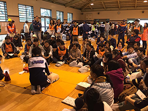 Volunteers interpreting how to perform CPR at a community disaster prevention drill